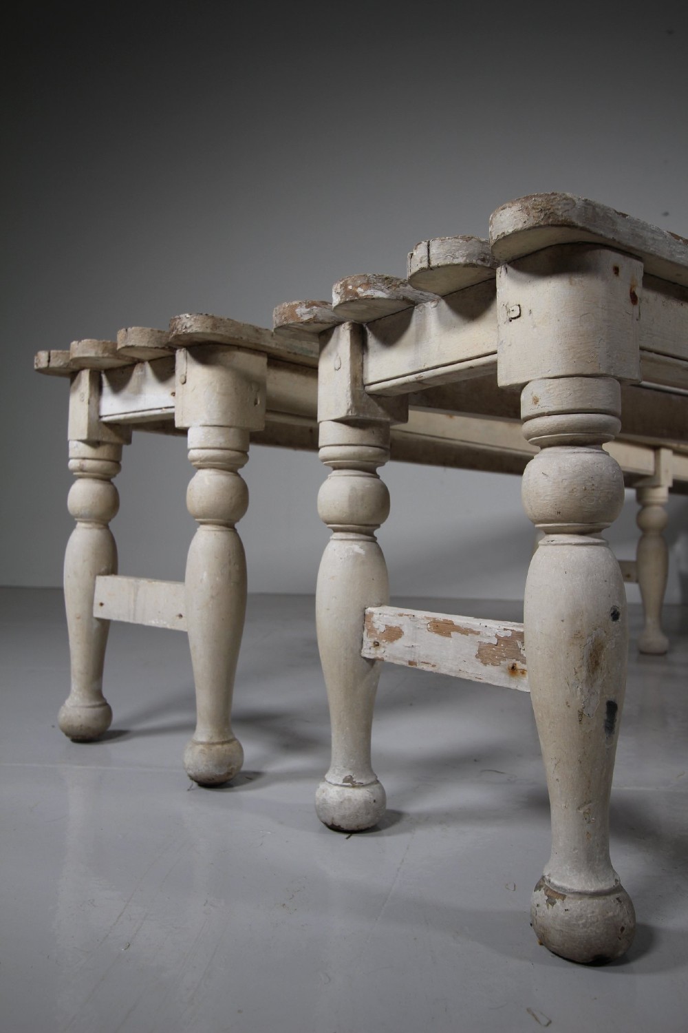 A pair of long 19th-century painted pine greenhouse benches featuring slatted tops and turned legs with lower stretchers. View VI