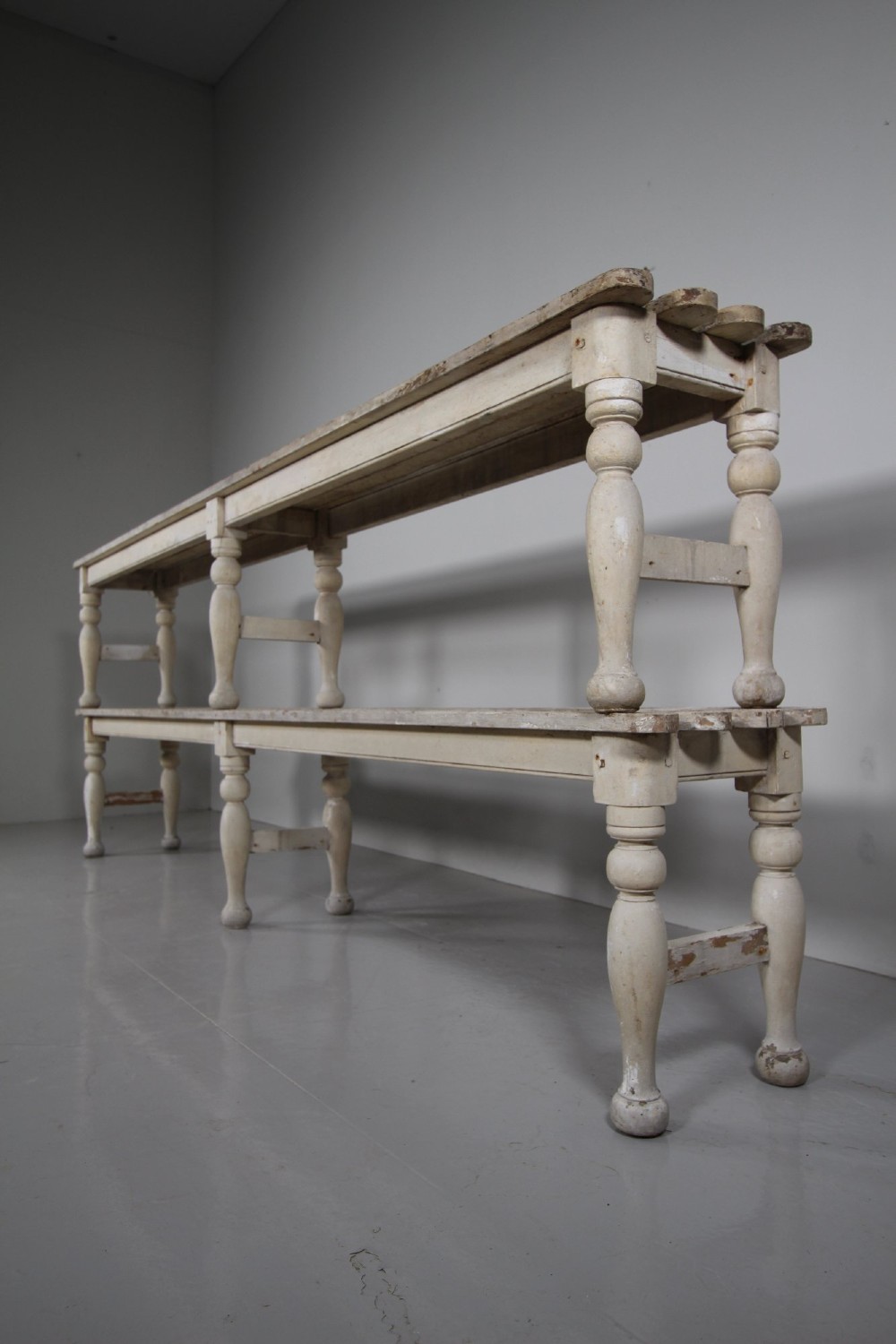 A pair of long 19th-century painted pine greenhouse benches featuring slatted tops and turned legs with lower stretchers. View IX