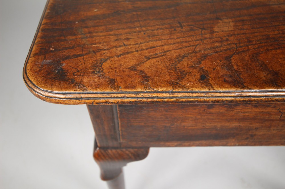 A Georgian dark oak side table featuring a single drawer with a brass handle, raised on slender tapered legs terminating in pad feet. View II