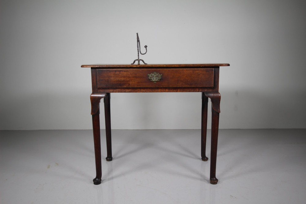 A Georgian dark oak side table featuring a single drawer with a brass handle, raised on slender tapered legs terminating in pad feet. View III