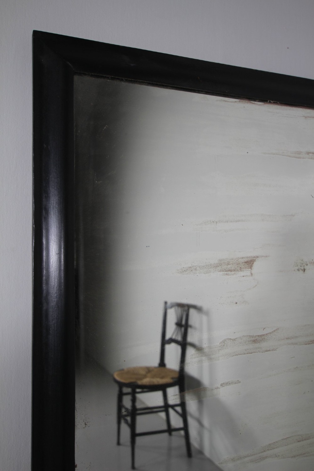 Large 19th-century rectangular mirror with a simple ebonised black wooden frame and patinated glass mirror. View II