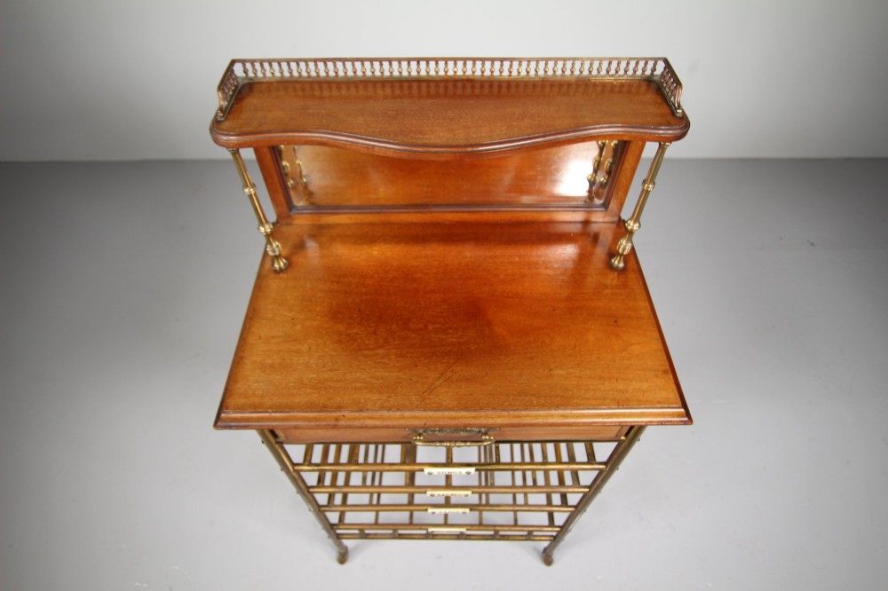 A 19th-century English Victorian brass and mahogany sheet music stand featuring open slatted shelves with ceramic labels, a top drawer, and a mirrored upper gallery. View VI