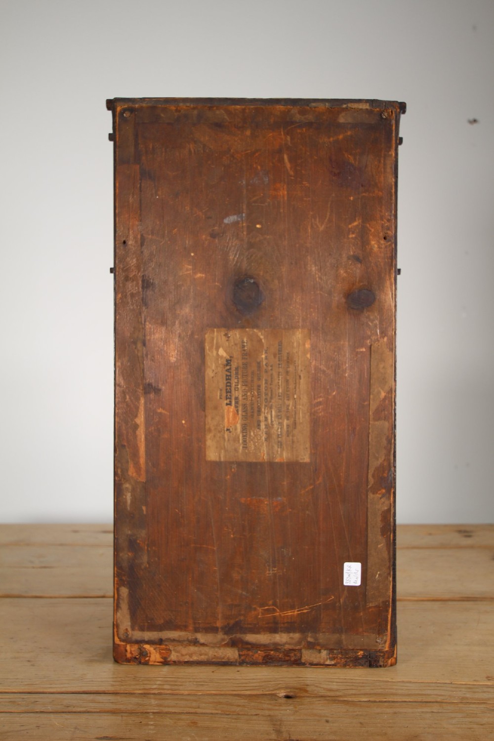 An early 19th-century rectangular wall mirror featuring a dark painted wooden frame with stencilled foliate borders and two reverse-painted glass panels displaying rural landscape scenes. View VI