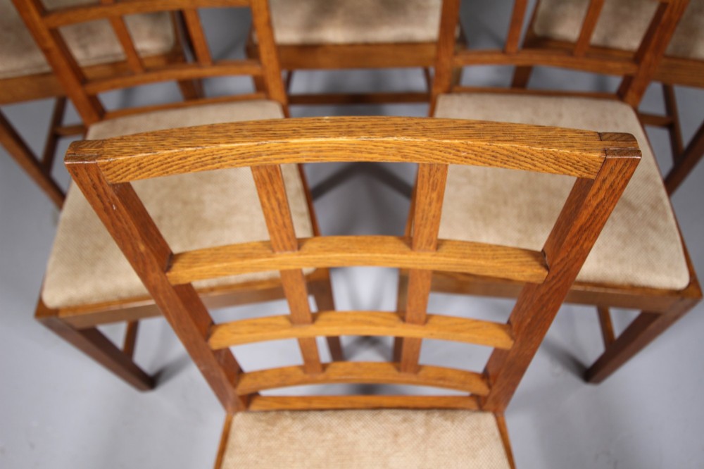 A set of six 1930s solid oak dining chairs featuring geometric lattice backs and upholstered neutral fabric seats. View II