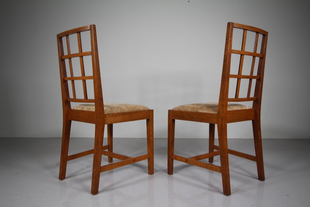 A set of six 1930s solid oak dining chairs featuring geometric lattice backs and upholstered neutral fabric seats. View IV
