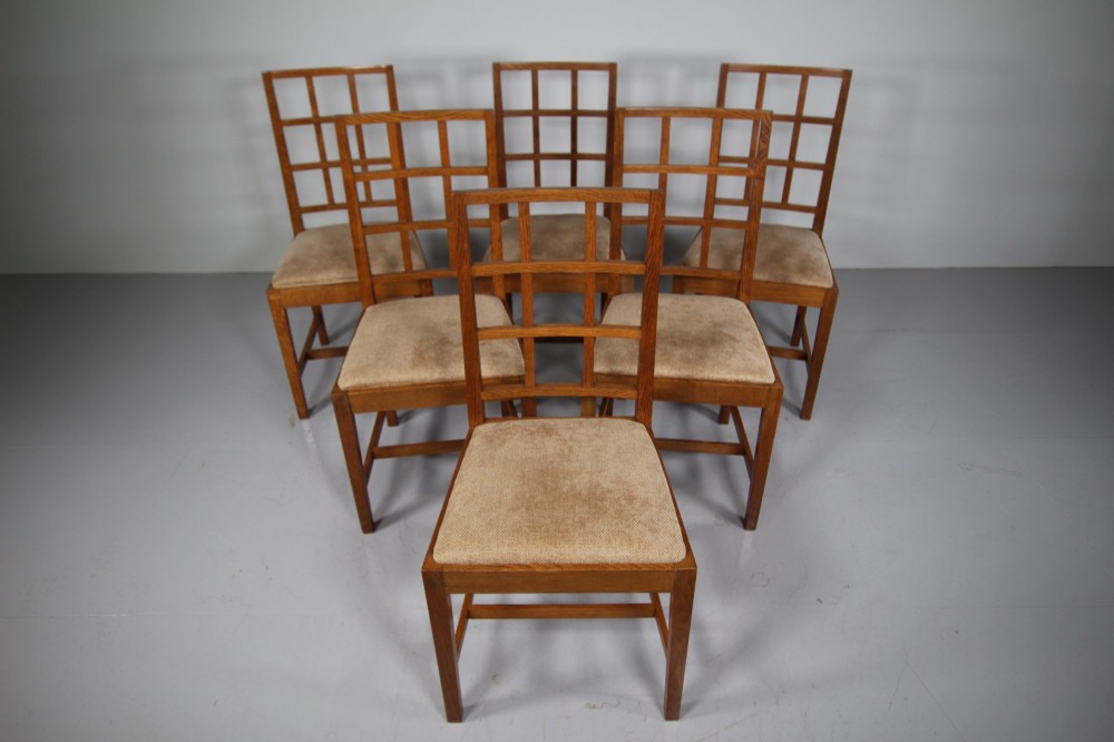 A set of six 1930s solid oak dining chairs featuring geometric lattice backs and upholstered neutral fabric seats. View VII