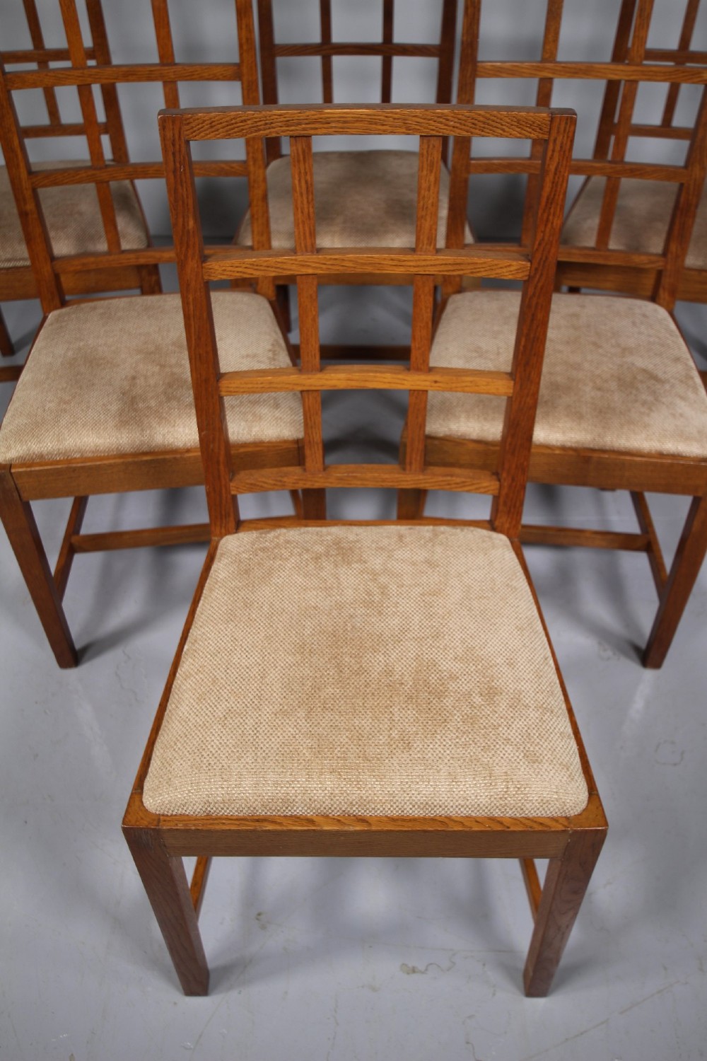 A set of six 1930s solid oak dining chairs featuring geometric lattice backs and upholstered neutral fabric seats. View VIII