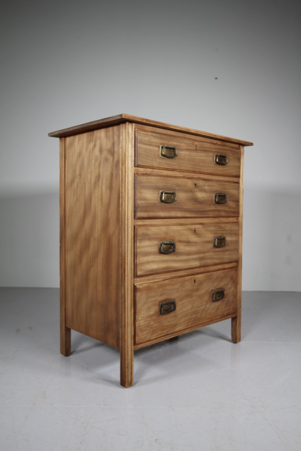 An antique colonial mahogany chest of drawers featuring four graduated drawers with flush brass handles standing on straight square legs. View VII