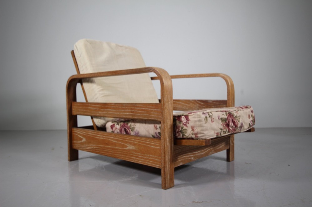 A 1930s solid oak reclining armchair frame featuring curved bentwood armrests, a slatted timber backrest, and an un-upholstered seat base. View III