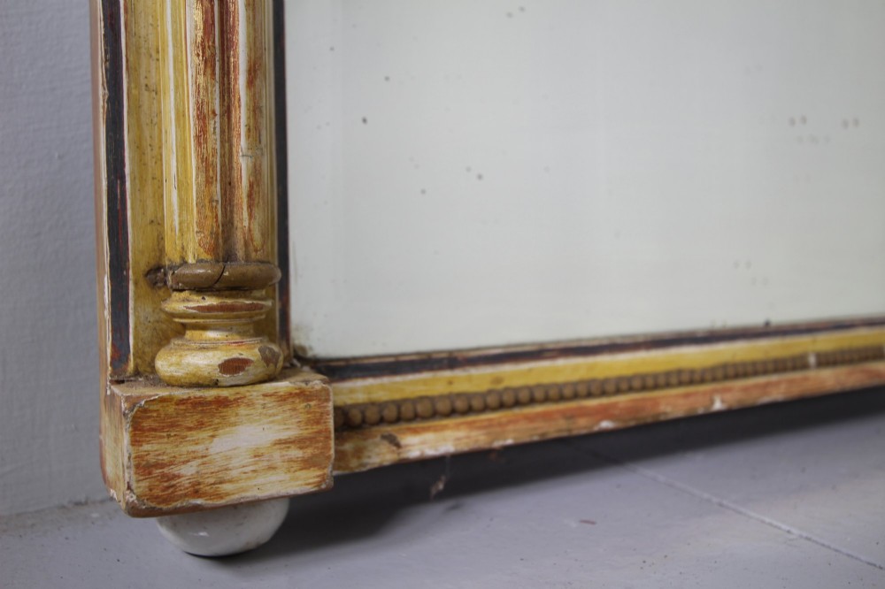 A tall nineteenth-century English Regency pier mirror featuring a cream and gilt frame flanked by fluted Corinthian columns and a decorated frieze. View IV