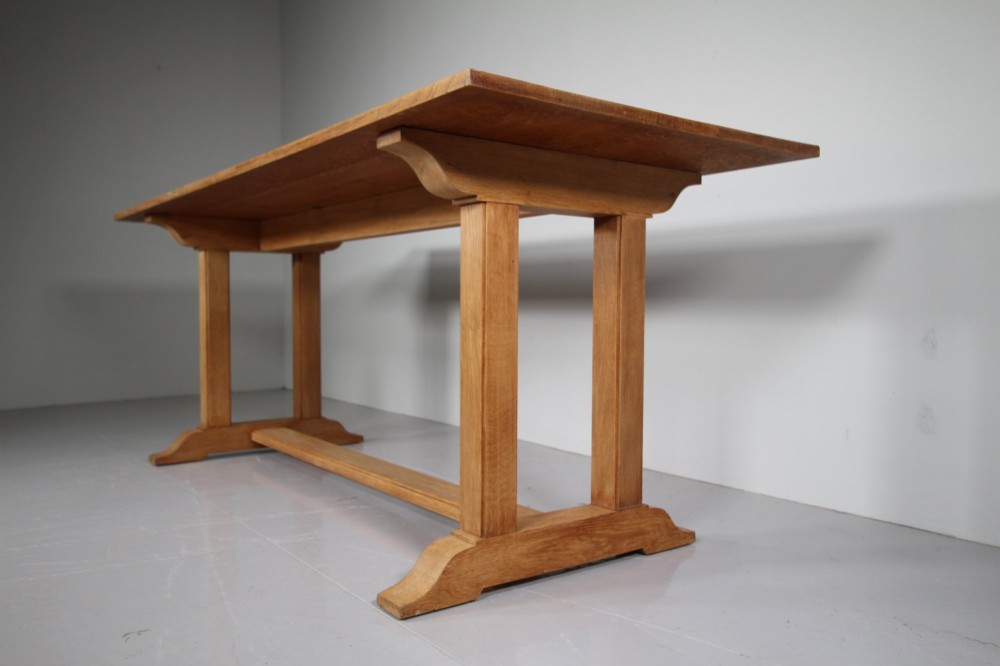 A 1930s solid oak refectory dining table featuring a plain rectangular top, twin upright trestle end supports, and a low central stretcher beam. View III