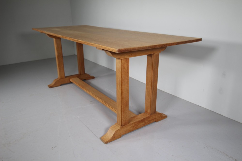 A 1930s solid oak refectory dining table featuring a plain rectangular top, twin upright trestle end supports, and a low central stretcher beam. View IV