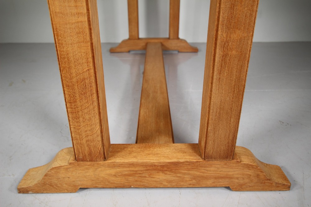 A 1930s solid oak refectory dining table featuring a plain rectangular top, twin upright trestle end supports, and a low central stretcher beam. View VI