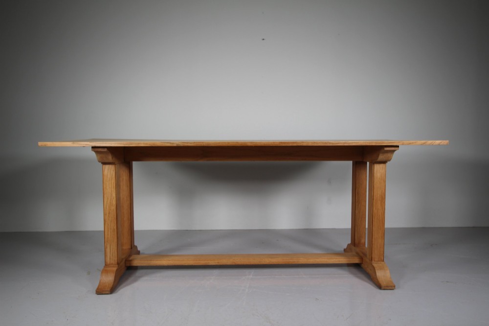 A 1930s solid oak refectory dining table featuring a plain rectangular top, twin upright trestle end supports, and a low central stretcher beam. View IX
