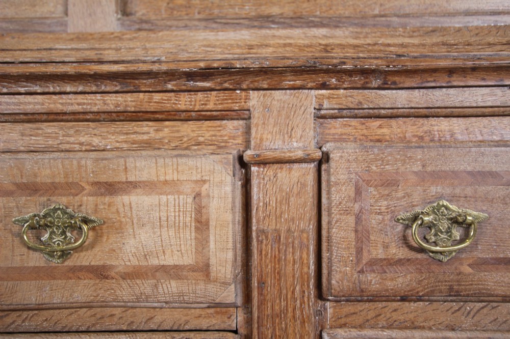A tall two-part 17th-century Welsh oak press cupboard featuring panelled doors with star inlay motifs above a chest base with multiple drawers. View IX