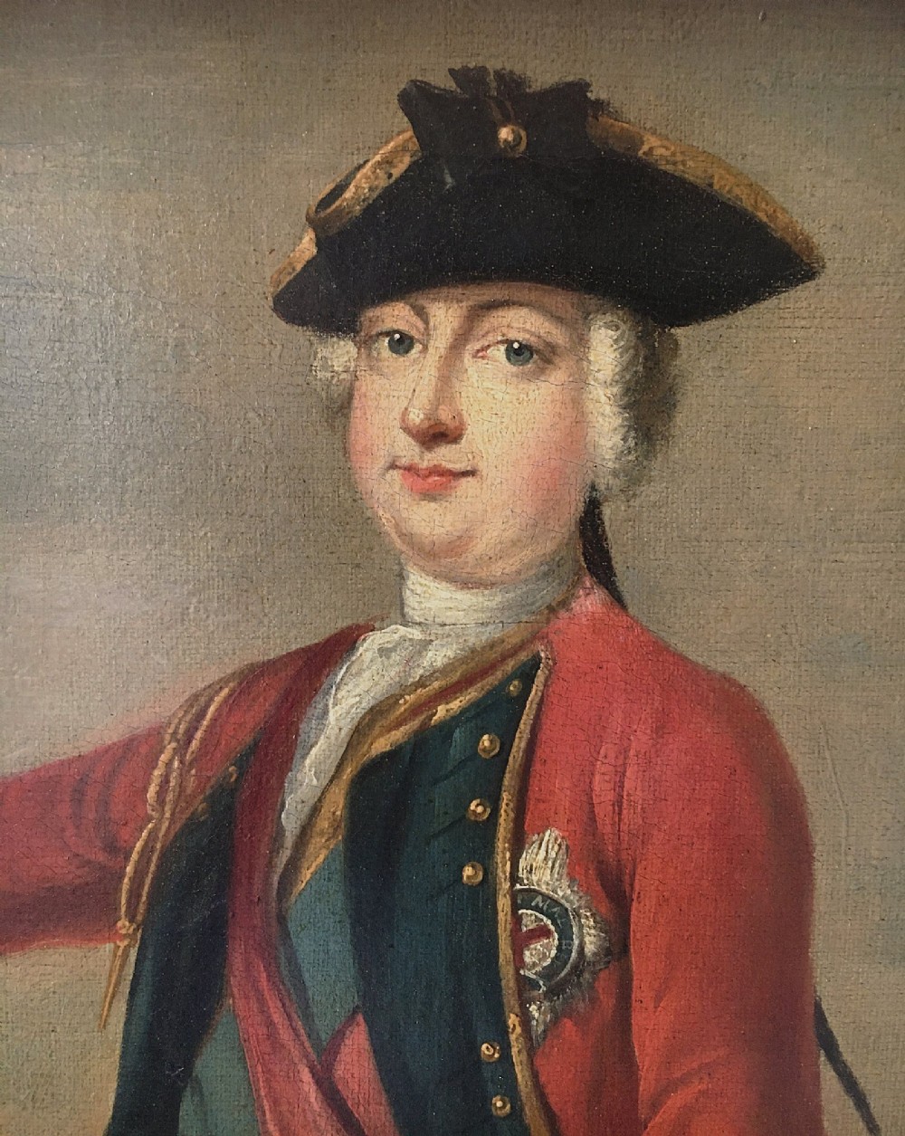 An 18th-century equestrian oil portrait depicting a military officer in a red coat mounted on a brown horse, enclosed in a carved giltwood frame. View V