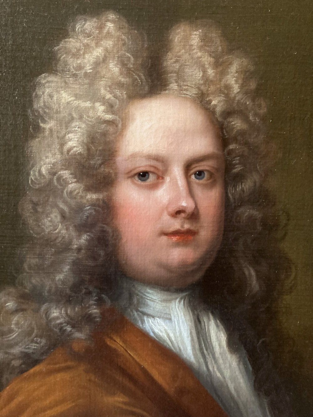 An 18th-century oil portrait depicting a gentleman with a grey periwig and brown mantle within a feigned oval background. View III