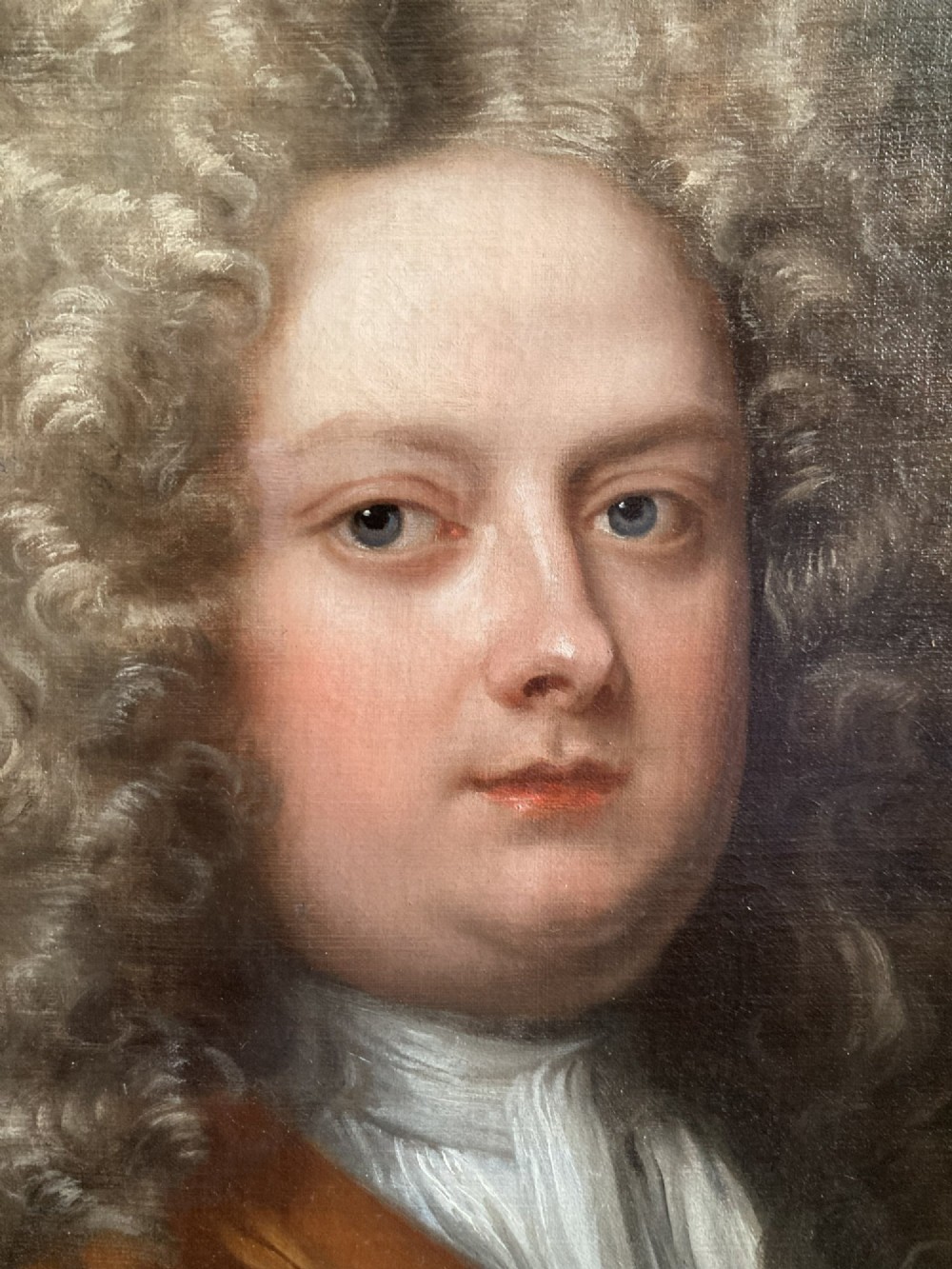 An 18th-century oil portrait depicting a gentleman with a grey periwig and brown mantle within a feigned oval background. View IV