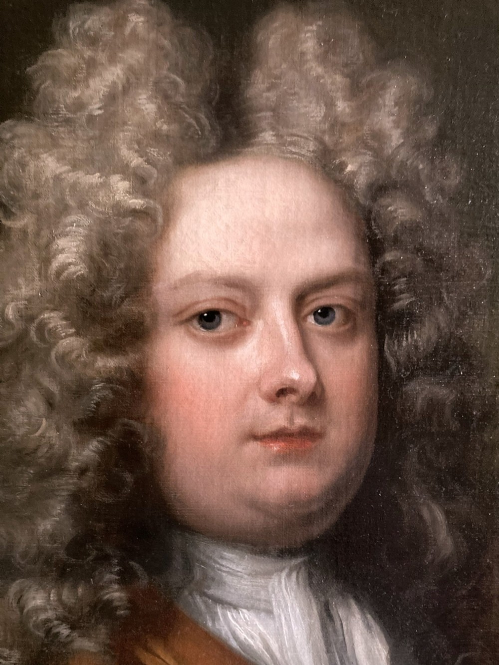 An 18th-century oil portrait depicting a gentleman with a grey periwig and brown mantle within a feigned oval background. View V