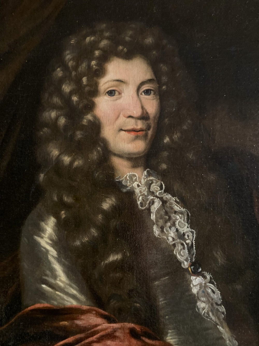 A 17th-century oil painting depicting a gentleman wearing a full wig and lace cravat in an ornate carved gold leaf frame. View IV
