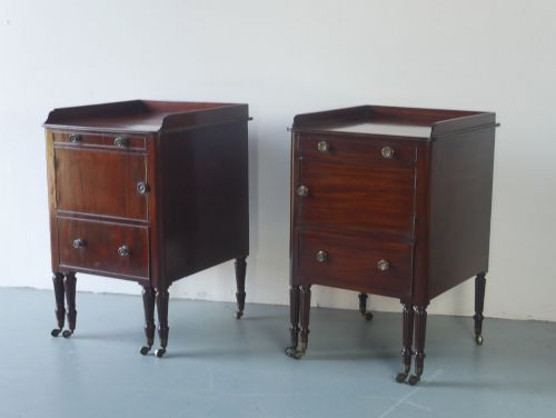 fig 1. A matched pair of dark mahogany Regency bedside cupboards featuring gallery tops, single cupboard doors, lower drawers, reeded legs, and brass castors.