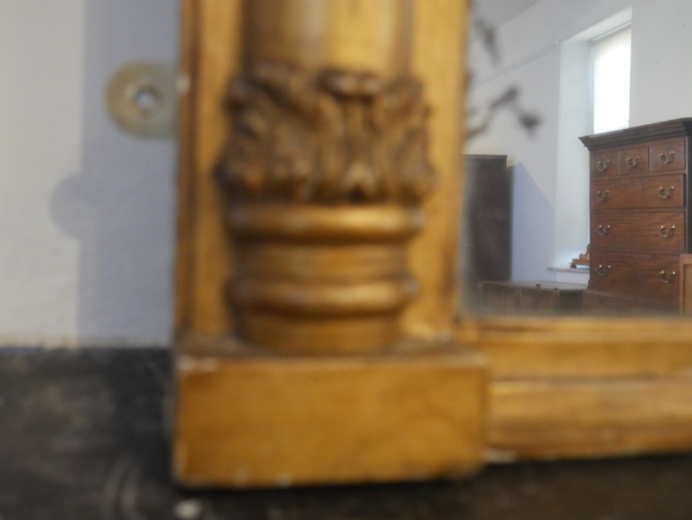 A broad rectangular late Regency giltwood overmantel mirror featuring a reeded frame with carved corner rosettes and central moulding accents. View V