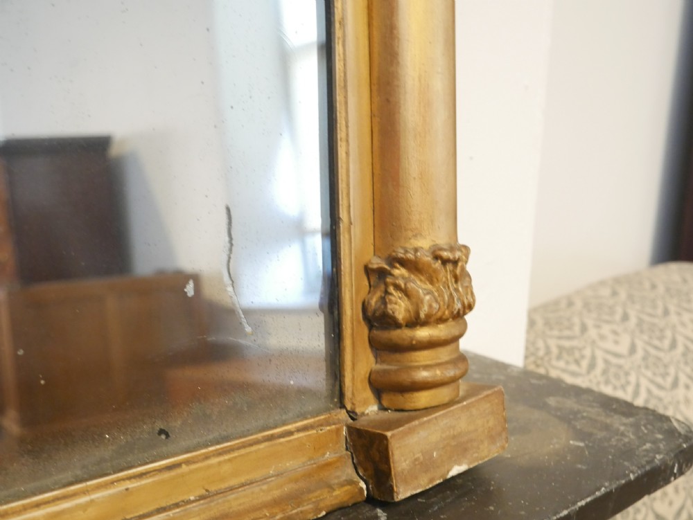 A broad rectangular late Regency giltwood overmantel mirror featuring a reeded frame with carved corner rosettes and central moulding accents. View VI