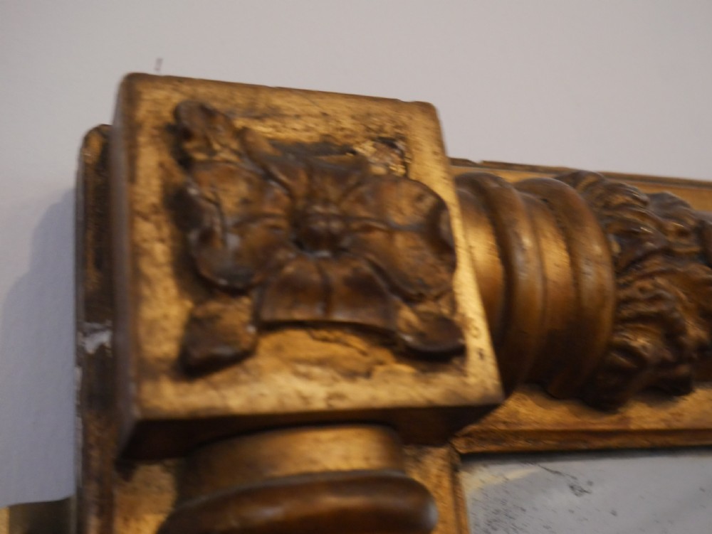 A broad rectangular late Regency giltwood overmantel mirror featuring a reeded frame with carved corner rosettes and central moulding accents. View VII