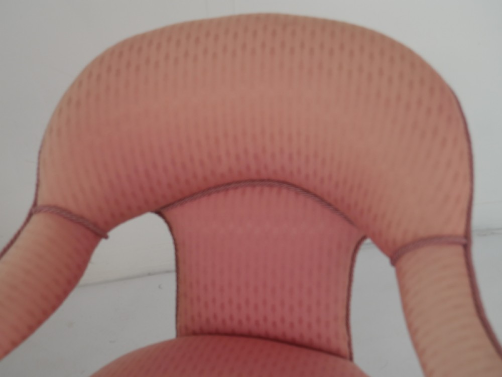 A Victorian armchair upholstered in dusty pink patterned fabric featuring carved walnut barley-twist legs and arm supports set on brass castors. View VIII