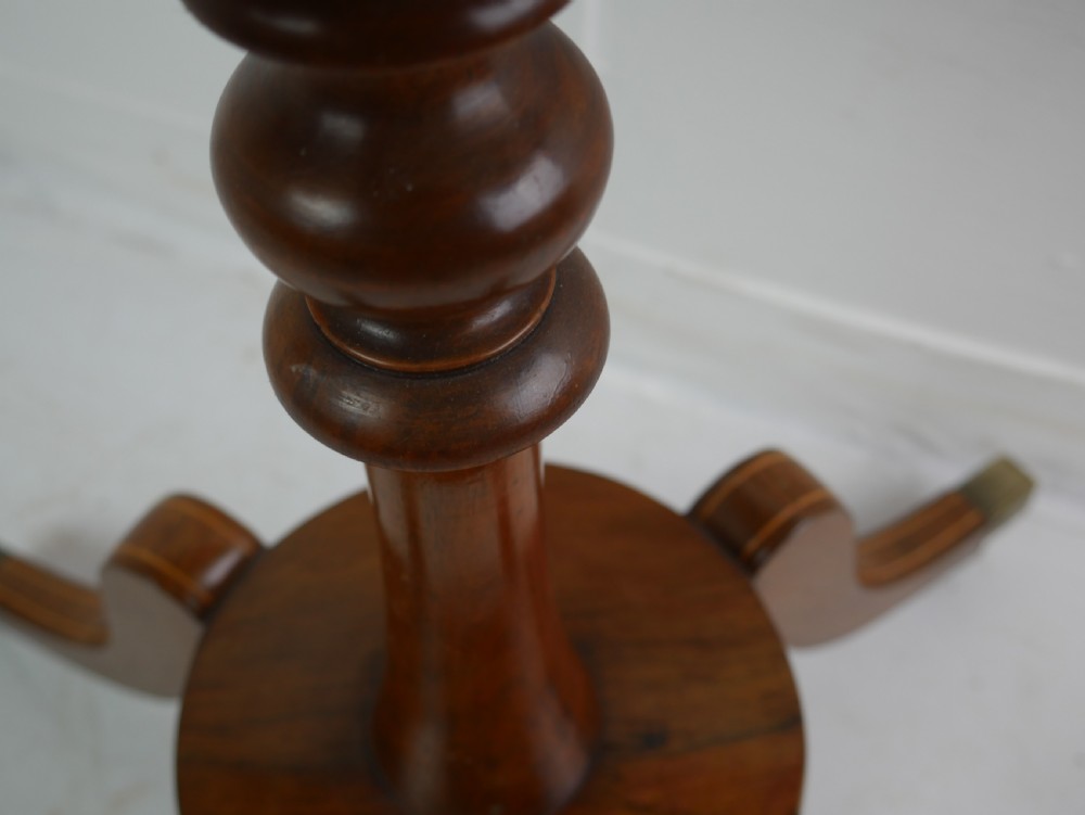 A Regency mahogany sewing table featuring a rectangular top with string inlay, a pleated red fabric work bin below, a turned pedestal support, and four splayed legs with brass castors. View VIII