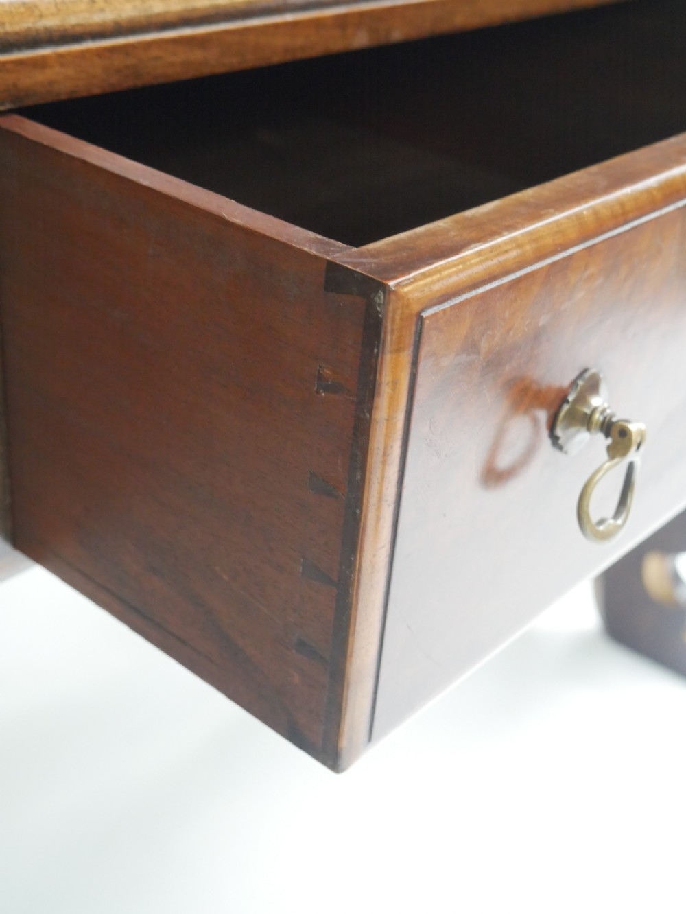 A large antique Scottish mahogany and walnut serving table featuring four brass-handled drawers, carved scroll leg supports, and a low rear gallery back. View IV
