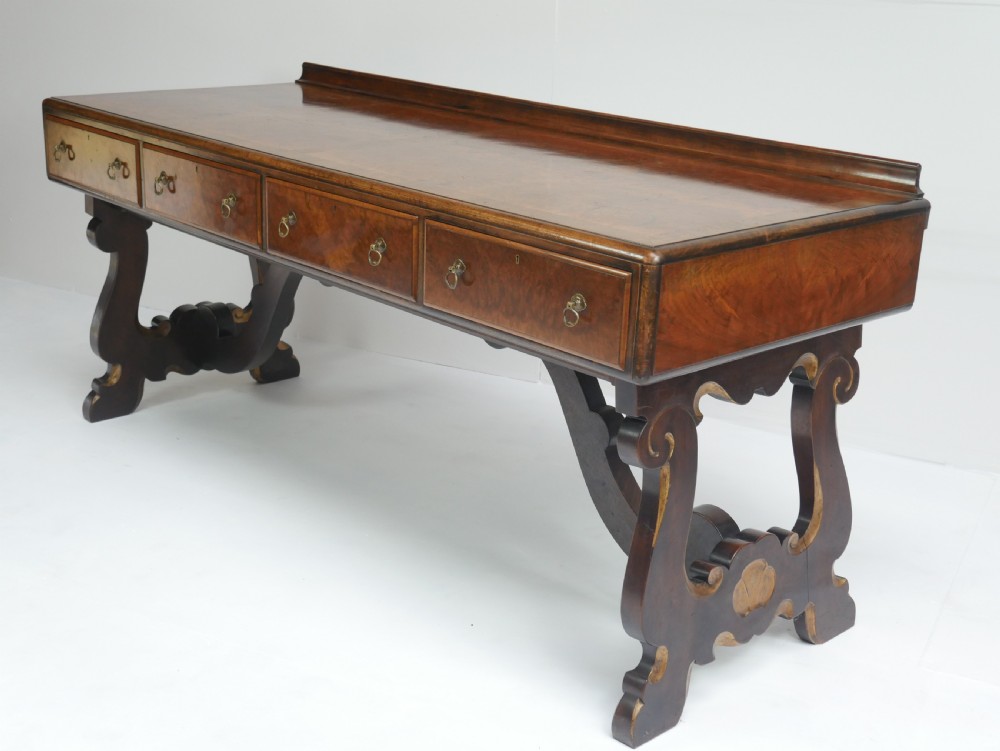 A large antique Scottish mahogany and walnut serving table featuring four brass-handled drawers, carved scroll leg supports, and a low rear gallery back. View VI