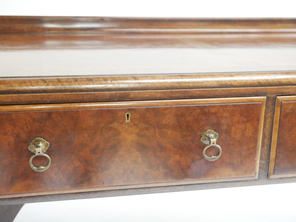 A large antique Scottish mahogany and walnut serving table featuring four brass-handled drawers, carved scroll leg supports, and a low rear gallery back. View VII