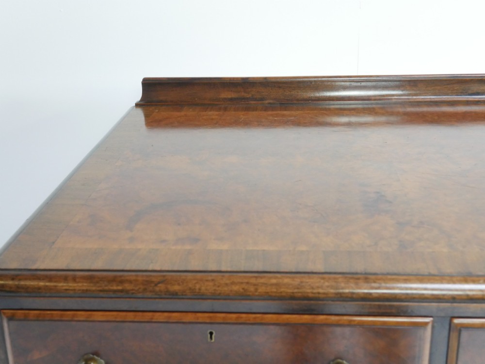 A large antique Scottish mahogany and walnut serving table featuring four brass-handled drawers, carved scroll leg supports, and a low rear gallery back. View VIII