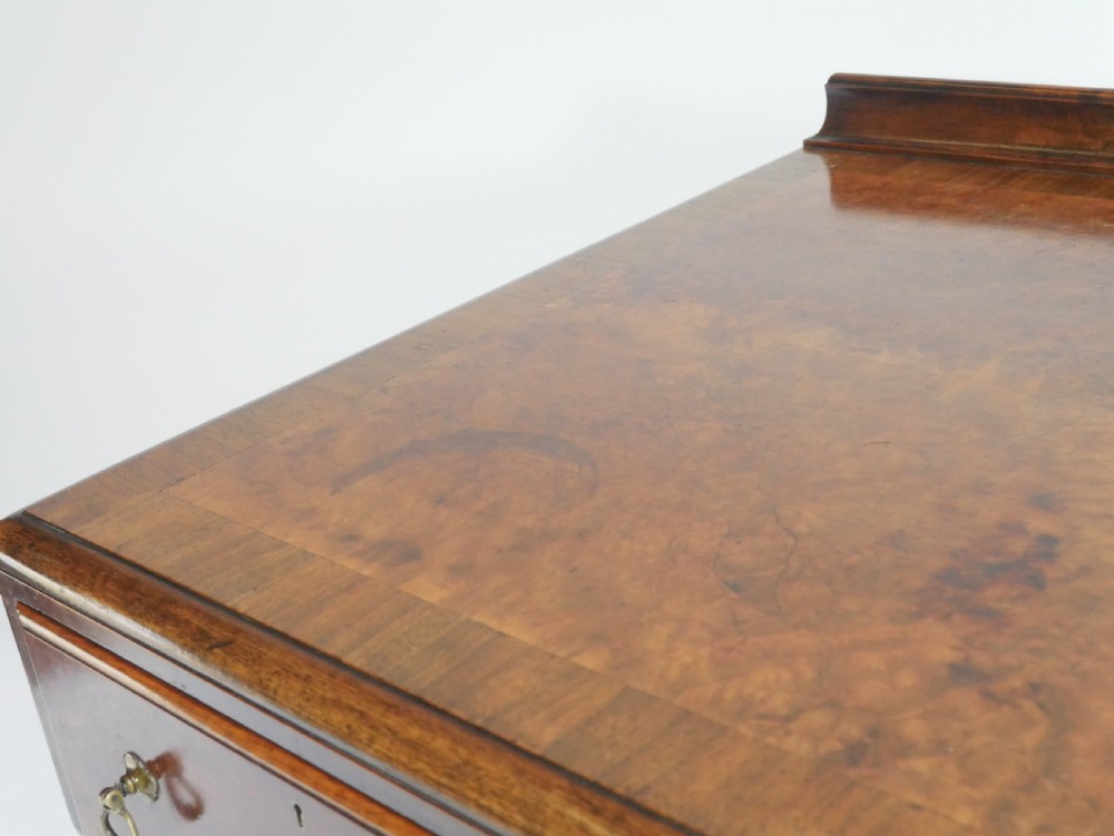 A large antique Scottish mahogany and walnut serving table featuring four brass-handled drawers, carved scroll leg supports, and a low rear gallery back. View XVII
