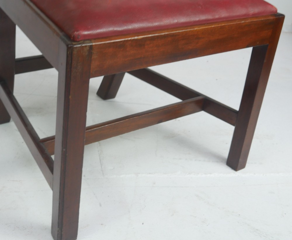 A pair of 19th-century mahogany side chairs with pierced back splats, serpentine top rails, straight legs with stretchers, and red leather seats. View X