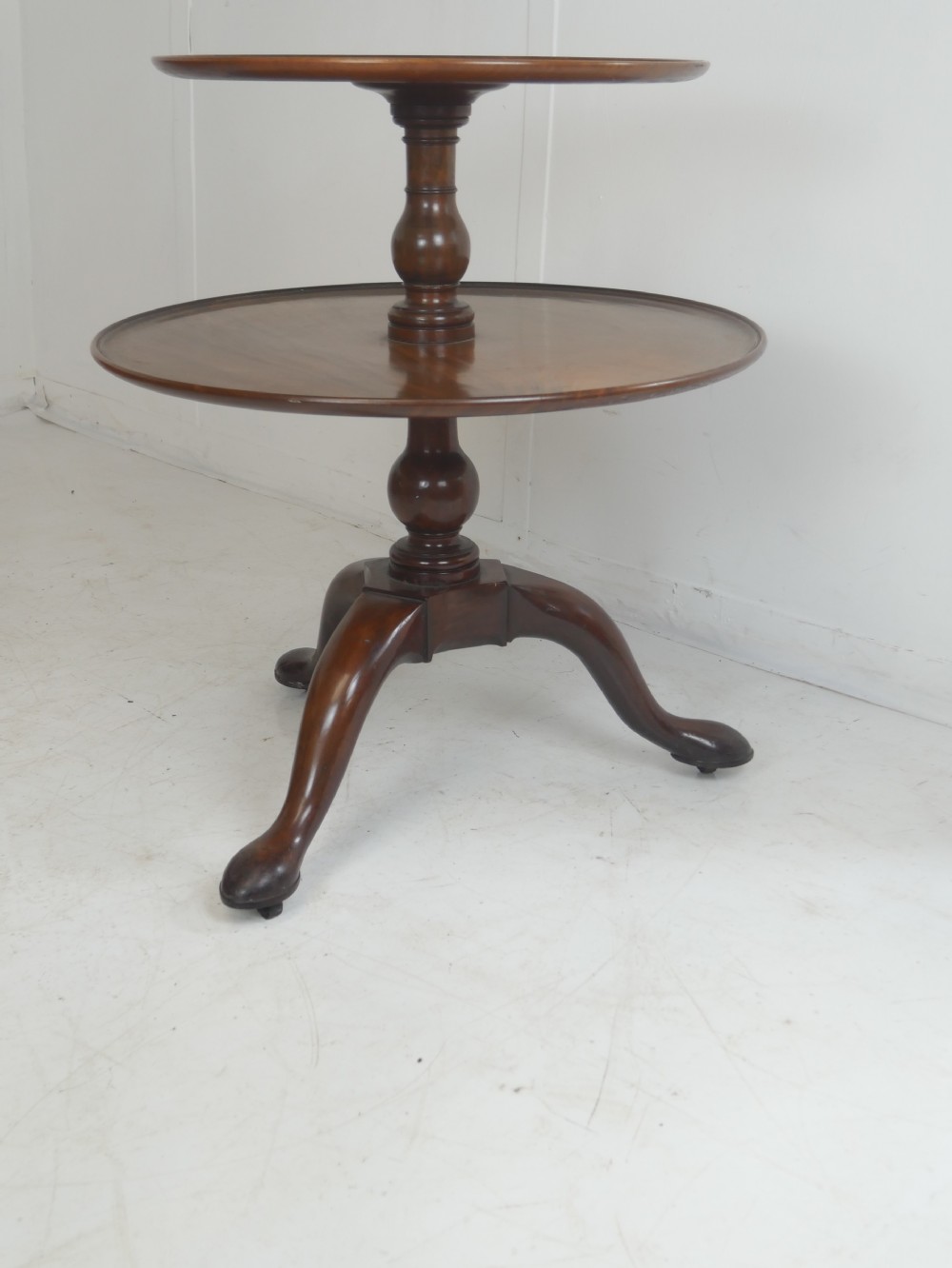 An 18th-century Georgian mahogany two-tier dumb waiter table with two graduated circular tray-moulded platforms on a turned baluster column and tripod pad feet. View VIII