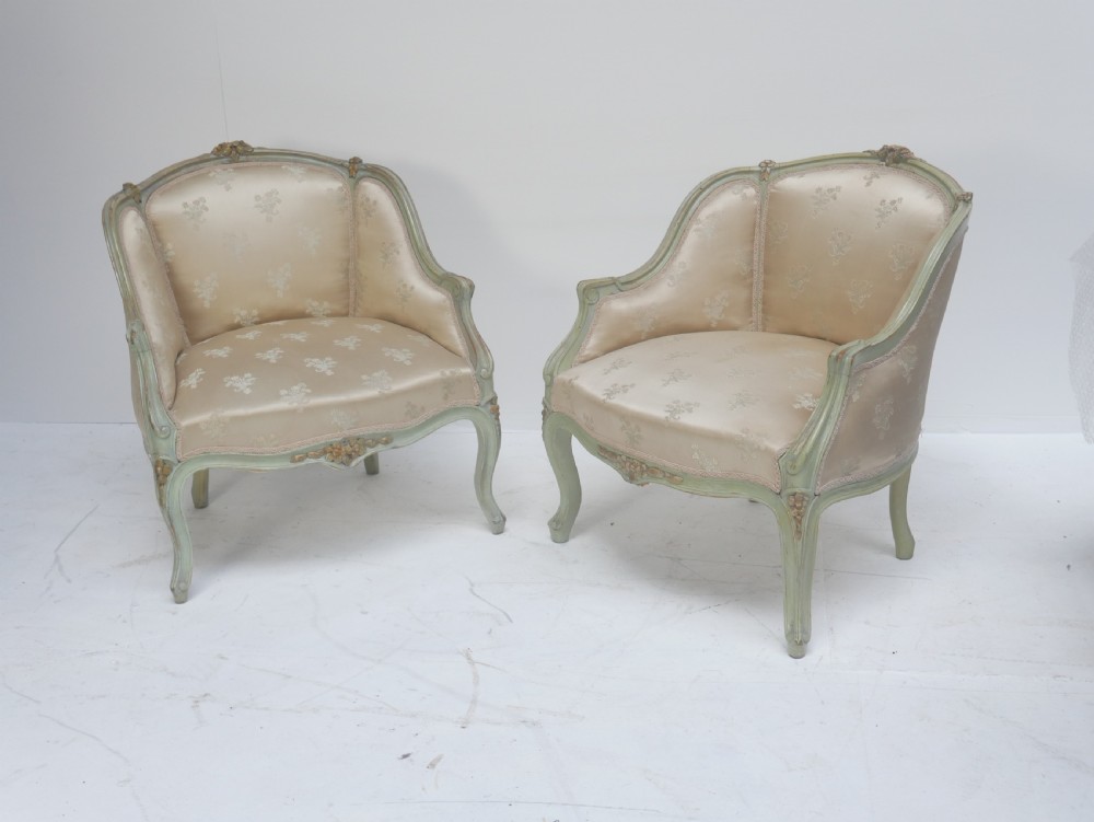 A pair of antique Scandinavian armchairs featuring pale green carved painted frames, cabriole legs, and cream floral pattern damask upholstery.