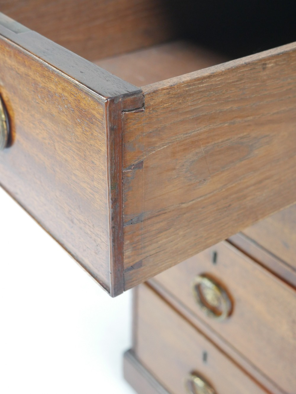 A Georgian mahogany kneehole desk featuring multiple side drawers with brass ring handles and a plinth base. View VIII