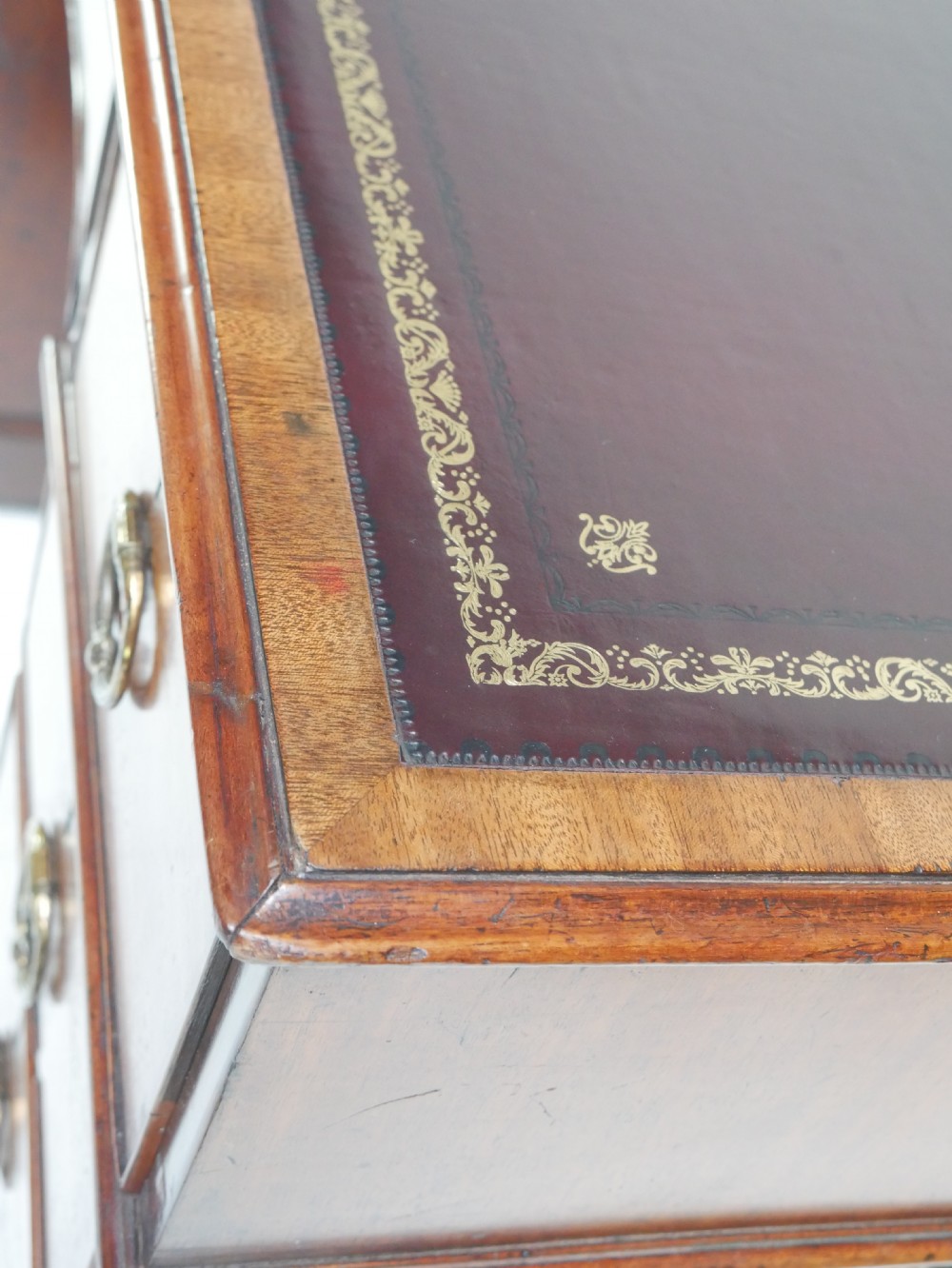 A Georgian mahogany kneehole desk featuring multiple side drawers with brass ring handles and a plinth base. View III