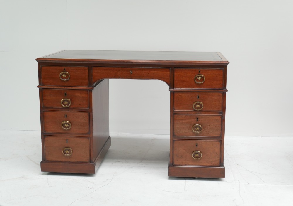 A Georgian mahogany kneehole desk featuring multiple side drawers with brass ring handles and a plinth base. View XIII