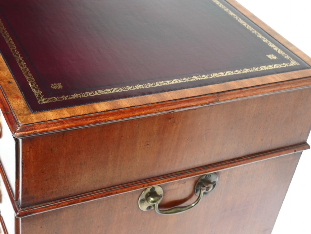 A Georgian mahogany kneehole desk featuring multiple side drawers with brass ring handles and a plinth base. View XV