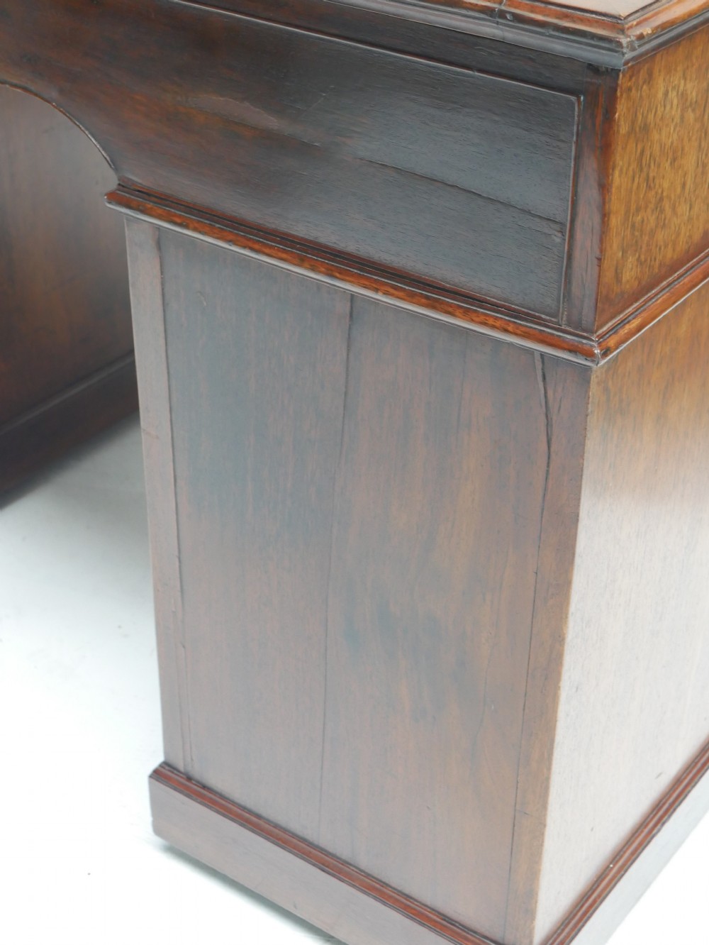 A Georgian mahogany kneehole desk featuring multiple side drawers with brass ring handles and a plinth base. View XII
