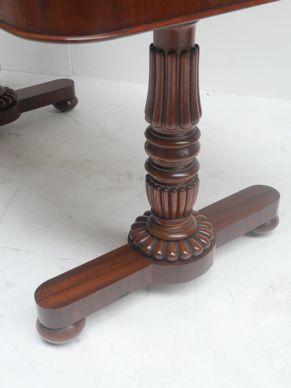 A Regency mahogany sofa writing table featuring a carved gadrooned edge, twin turned pedestal supports, and plinth feet. View III