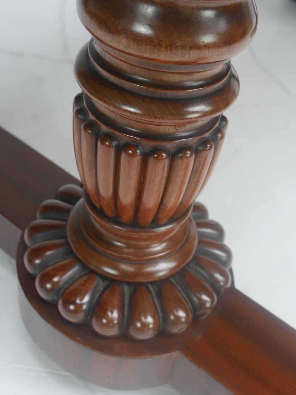 A Regency mahogany sofa writing table featuring a carved gadrooned edge, twin turned pedestal supports, and plinth feet. View VIII