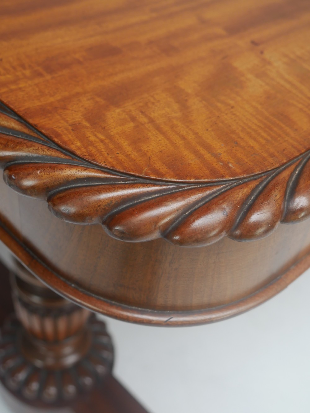 A Regency mahogany sofa writing table featuring a carved gadrooned edge, twin turned pedestal supports, and plinth feet. View IX