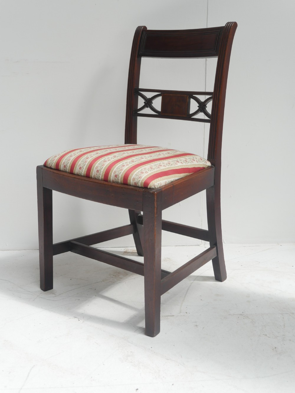 Set of four dark mahogany Regency dining chairs with reeded frames and red and cream striped fabric seats. View III