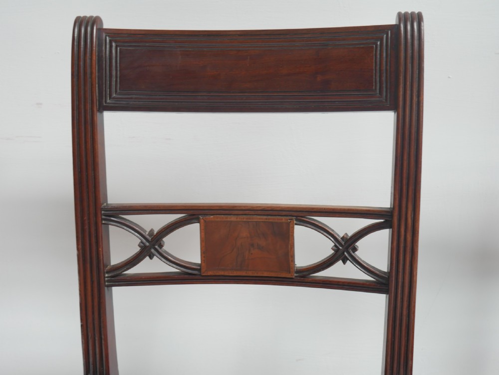 Set of four dark mahogany Regency dining chairs with reeded frames and red and cream striped fabric seats. View IV