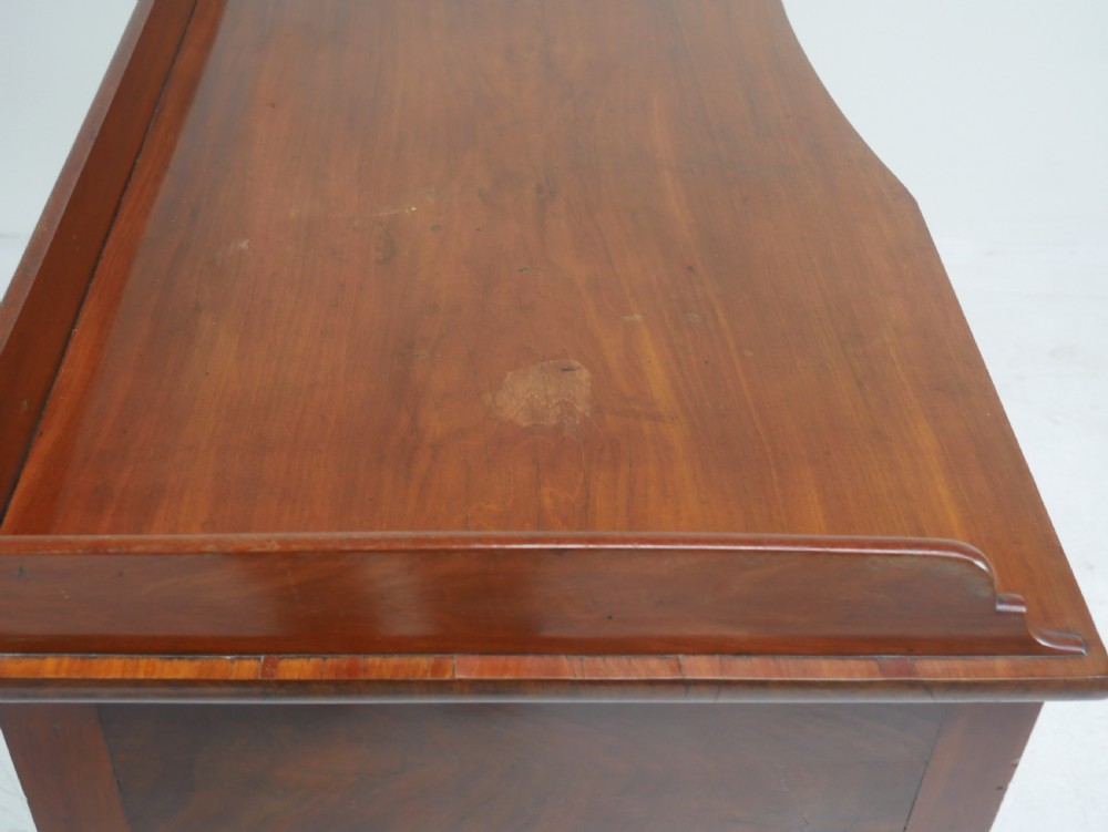 A Regency flame mahogany sideboard featuring five drawers with brass lion mask handles, turned reeded legs, and carved corner brackets. View XI
