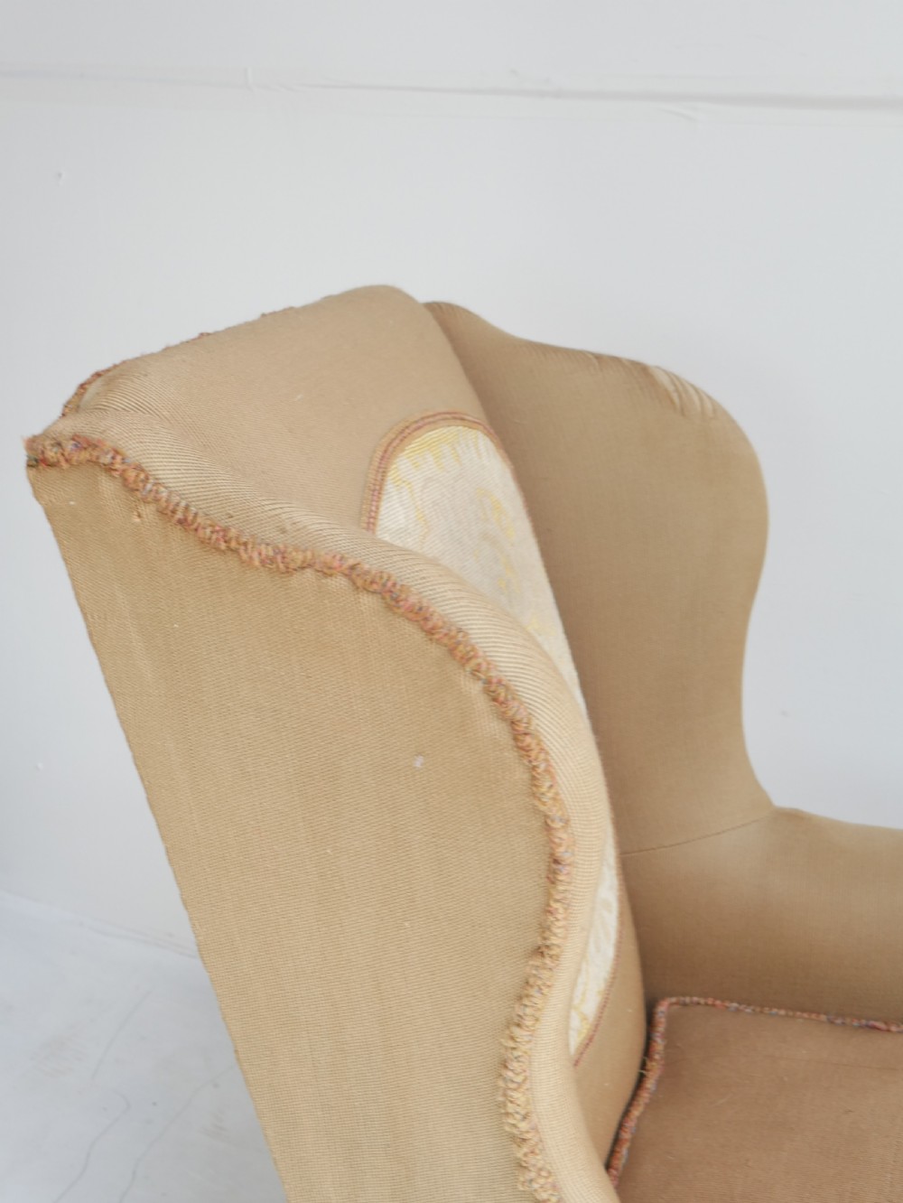 A pair of 1920s wingback armchairs upholstered in gold fabric featuring oval embroidered back panels and carved walnut ball and claw feet. View II